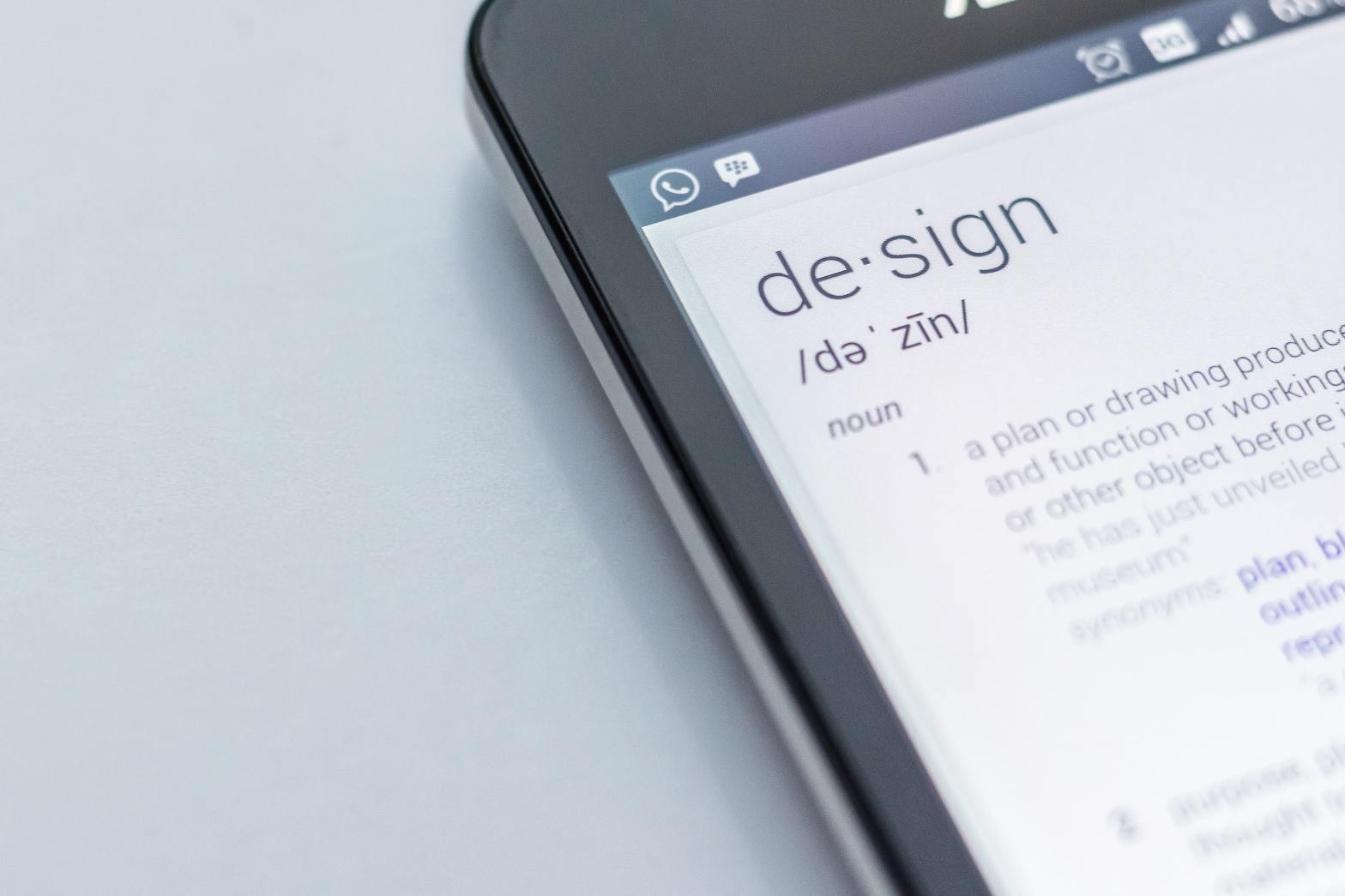 corner of mobile device showing the definition for design on screen
